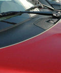 Chrome U-channel edge guard trim on red car hood near windshield, front view