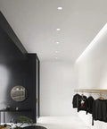 10 Pack 7W Led Recessed Ceiling Downlights Dimmable Round Panel With Polished Stainless Trim lighting a modern clothing store interior.