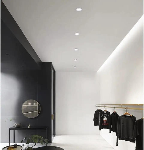 10 Pack 7W Led Recessed Ceiling Downlights Dimmable Round Panel With Polished Stainless Trim lighting a modern clothing store interior.