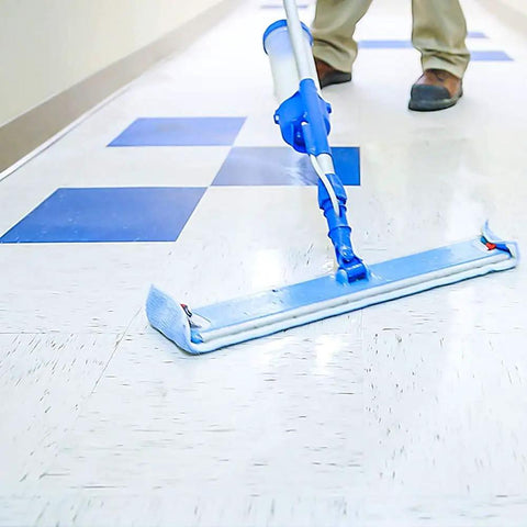 Person cleaning a vinyl floor with a blue mop using Badass Professional Floor Sealant With Tough Stain Guard For Vinyl Vct Concrete.