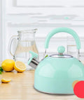 Heavy Duty Stainless Steel Water Kettle With Slick Pastel Exterior And Zero Scald Handles Providing A Dang Fast Boil Speed While Incorporating A Trustworthy Auto Whistle Alarm For Daily Household Prep on wooden surface with lemons.