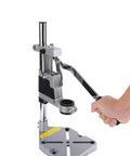Adjustable Desktop Drill Stand With Universal Bench Clamp And Workbench Support shown in aluminum with a hand adjusting depth lever