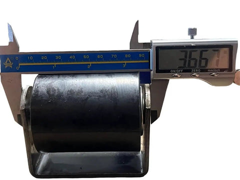 Close-up of 3-inch guiding roller for sliding gates with weld-on bracket, measured with caliper for precise dimensions.