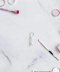 Stainless Steel R Shape Cotter Pins 8 Pack With Wavy Locking Design For Secure Industrial Hitch Connections And Mechanical Fasteners That Prevent Loosening on marble background with makeup tools.