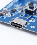 Close-up of Power-Z SINK240 USB PD3.1 Trigger Board showing USB-C port, electronic components on blue circuit board.