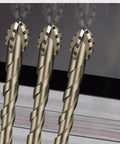 Front view: three carbide-tipped sawtooth eccentric drill bits with hex shanks.