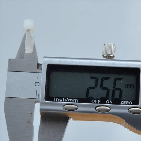 Measuring a Premium White Nylon Hex Standoff Spacer with calipers showing 256 mm, ideal for PCB and build projects.