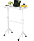 Top Shelf Rolling Sit Stand Desk With Six Height Settings And Secure Lockable Casters Crafted For Taller Buyers To Hit The Posture Sweet Spot And Keep Your Home Office Crisp Daily, white color with a laptop and a plant.