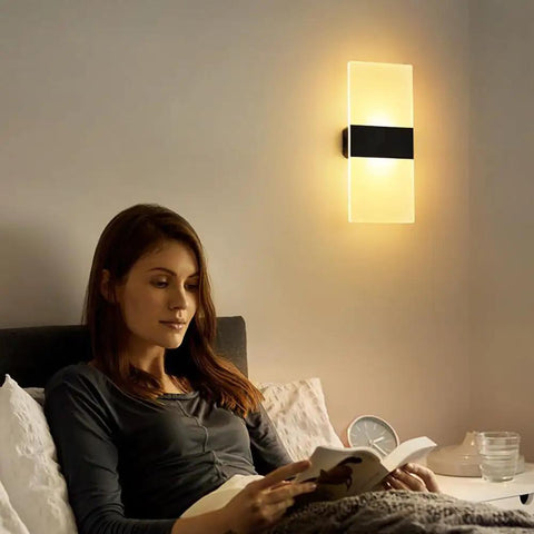 Rechargeable Battery Powered Wall Sconce Pair With Touch Dimming illuminating a bedroom, woman reading in cozy ambient lighting.