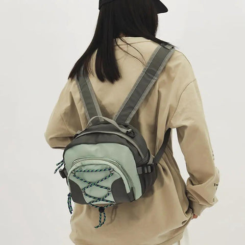 Person wearing a Lightweight Nylon Camping Backpack With Breathable Comfort Large Capacity Grey Build Durable Scratch Resistant Material Smooth Zippers For Easy Access Multi Carry Options From Backpack To Crossbody Go To Outdoor Adventures