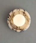 Alabaster Wall Sconce, 7.5" Natural Marble Wall Lamp with Milk Glass Shade top view showcasing round stone design with soft light.