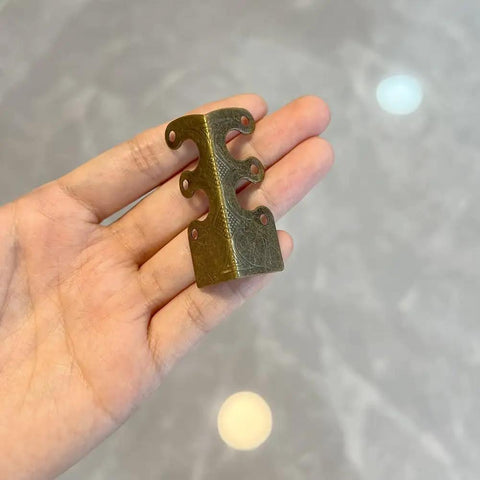 Top Shelf Solid Brass Baseboard Corner Guards For Walls And Skirting Boards, Vintage Bronze Edge Protectors For Furniture And Door Frames, Built Tough Rustproof Wall Bumpers With Screws Included displayed in hand.