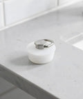 White Round Drain Stopper for Bathtubs and Kitchen Sinks on a smooth countertop, showcasing elegant minimalist silicone design.