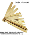 Brass feeler gauge set with 13 leaves fanned in angled view; 0.03–1.0 mm thickness range.