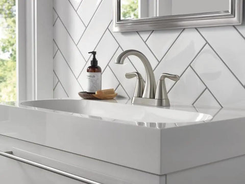 Arvo Centerset 2-Handle Bathroom Faucet in Brushed Nickel, SpotShield Stainless Finish on a white sink with chevron tile background.