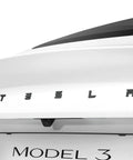 Rear view of Tesla Model 3 Highland with sleek black emblem protected by full cover sticker, visible on white car, premium PC material.