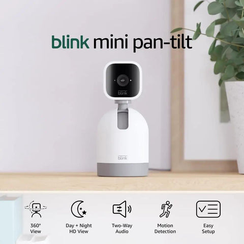 Smooth Swiveling Indoor Security Camera Locks Down Your Space With Crisp HD Video And Infrared Night Vision For Seamless Pan Tilt Coverage Plus Quick Plug And Play Two Way Audio Alexa Ready White displayed on a shelf with plant.