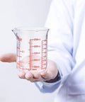 Person holding Borosilicate Glass Measuring Cup 1 Cup 8oz with Spout Your Go To Liquid Measuring Tool For Cooking And Cocktails Clear Readouts