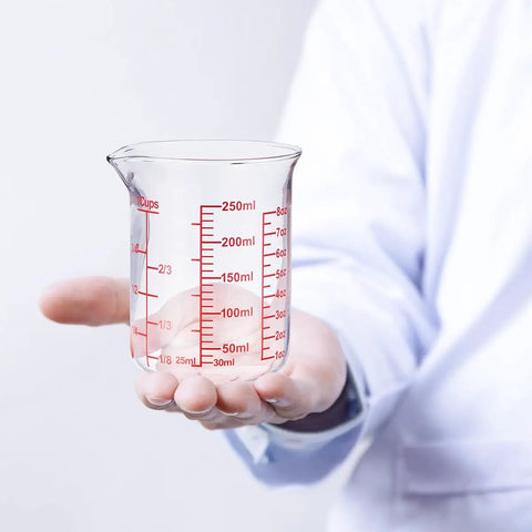 Person holding Borosilicate Glass Measuring Cup 1 Cup 8oz with Spout Your Go To Liquid Measuring Tool For Cooking And Cocktails Clear Readouts