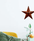 Rustic 3D Metal Barn Star Wall Decor Classic Country Vibe Indoor Outdoor 8 Inch Burgundy wall hanging in living room setting.