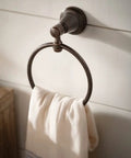 Wall-mounted bronze towel ring with white cloth hanging, suitable for home decor and bath use