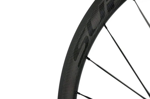 Close-up of Carbon Fiber Road Bike Wheelset 700c Clincher With 38mm Depth And 23mm Wide Rim showing Toray T700 material and spokes.