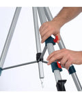 Hands adjusting the Lightweight Heavy Duty Aluminum Elevator Tripod With Precise Centimeter And Millimeter And Feet And Inches Graduations