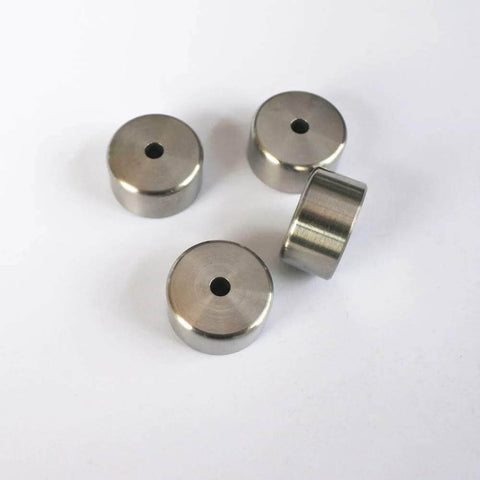 Four metal poppet seats for water jet cutting machines, round discs with center holes.