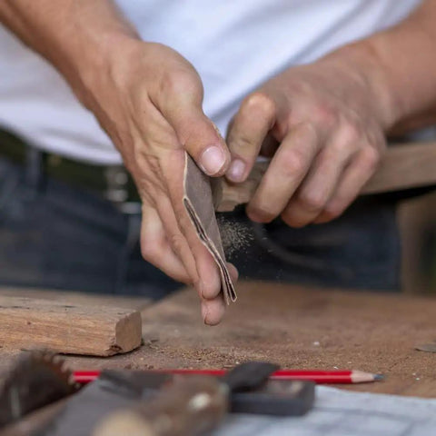 Person using Heavy Duty 100 Grit Multi Purpose Sandpaper Sheets 9 By 11 Inch Pack Of 25 on wood for fast smooth prep and finish