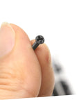 Close-up of a hand holding a screw from the 18 Piece Miniature Screw Set With Flat Countersunk Head Micro Screws For Glasses, Watches, And DIY Projects In A Clear Storage Box Ideal For Pros And DIYers Who Need Tiny Screws On Hand.
