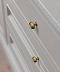 Close-up of two brass knobs on white cabinetry; Antique Brass Double Ring Oval Cabinet Knobs Set Of 12 For Kitchen And Furniture Vintage Hardware