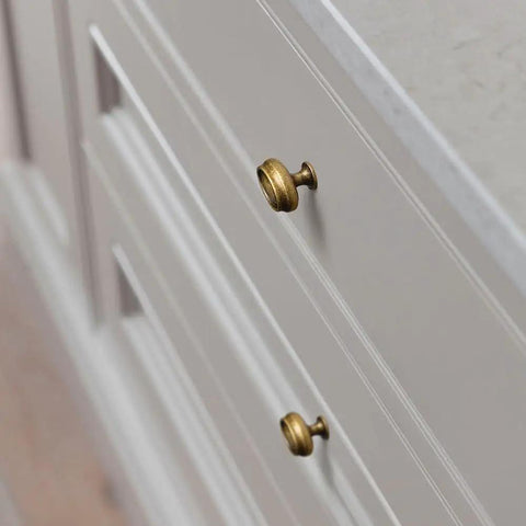 Close-up of two brass knobs on white cabinetry; Antique Brass Double Ring Oval Cabinet Knobs Set Of 12 For Kitchen And Furniture Vintage Hardware