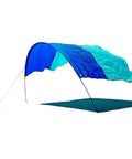 World's Best Beach Shade Wind Powered Shelter For The Beach Lightweight 4 Lb shown in Royal Blue and Teal setup on beach.