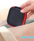 A hand holding a small square 6 Pack Tough As Nails PU Hard Shell Earbud Case with zipper, perfect for on-the-go.