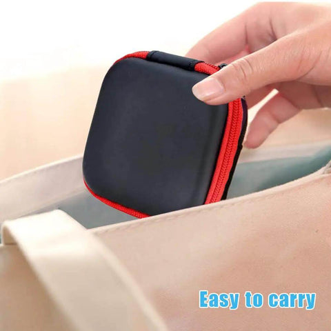 A hand holding a small square 6 Pack Tough As Nails PU Hard Shell Earbud Case with zipper, perfect for on-the-go.