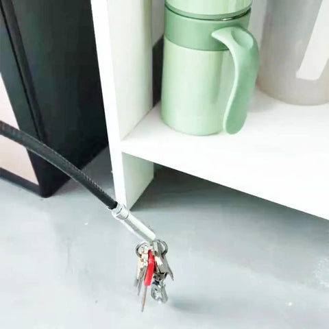 Ultra Slim 79 Inch Drain Snake Tool With Flexible Grabber Claw holding keys under shelf