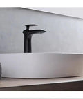 USZWBY Vessel Sinks Minimalist Ceramic Table Basin Home Hotel Bathroom Washbasin with sleek black faucet on wooden surface.