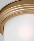 Close-up of satin brass 3 light flush mount ceiling light in Geary style with etched glass, modern look, steel construction.
