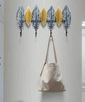 Slick Wall Mounted Coat Rack Heavy Duty Steel Hooks For Entryway Door Hallway Closet with leaf design and bag hanging.