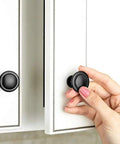 Hand installing Black Cabinet Knobs, 6 Pack, 1-1/4 Inch Round Single Hole Drawer Knobs For Dresser And Kitchen Cabinets on white cabinet