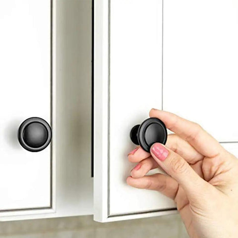 Hand installing Black Cabinet Knobs, 6 Pack, 1-1/4 Inch Round Single Hole Drawer Knobs For Dresser And Kitchen Cabinets on white cabinet