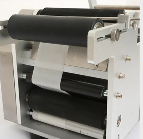Close-up of semi auto round bottle labeling machine showing black rollers and aluminum alloy frame for precise application.