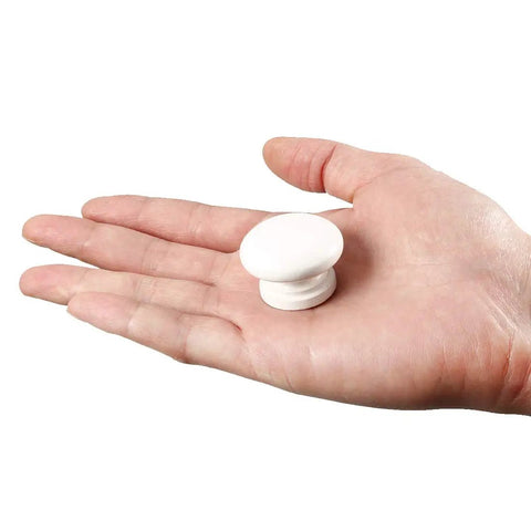 Five Piece White Wooden Cabinet Knobs For Kitchen Drawers And Cupboard Doors, decorative round knob held in hand for size scale.