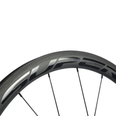Close-up of Carbon Fiber Wheelset 38mm And 23mm Rim Depths 700c Clincher with basalt brake surface and aero spoke design.