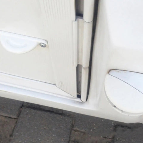Close-up of RV door with Premium 2 Pack White Rv Door Stop Retainer Tool for Motorhomes and Travel Trailers holding door securely.