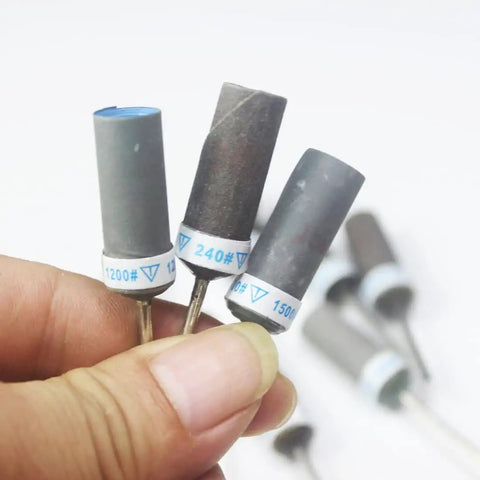 Hand holding 10 Pcs Mixed Grit Sandpaper Drum Set For Dremel Rotary Tools 1 Eighth Inch Shank Abrasive Sanding Sleeve Rolls