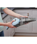Person using Cordless Handheld Vacuum Cleaner For Home And Car With Crevice Attachment, showing translucent dirt bowl.