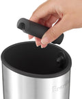 Breville BEA501BSS knock box; close-up of hand inserting a black accessory into a brushed stainless steel container.