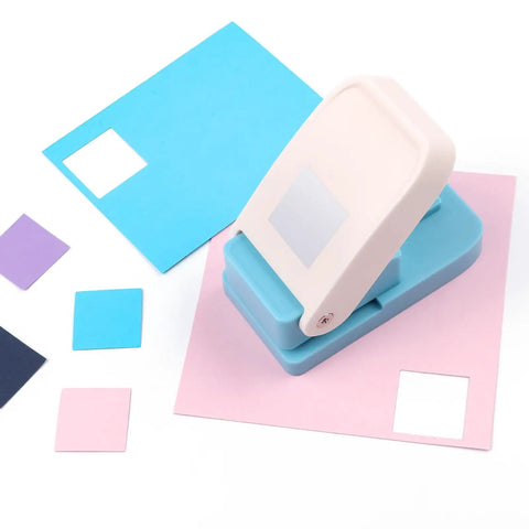 1 Inch Square Punch Lever Action Craft Punch for Paper Crafting and Scrapbooking cutting colored paper squares on a tabletop