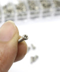 Hand holding silver screw from Miniature Screw Kit Set With Silver Tiny Screws For Eyeglasses, Sunglasses And Watches, Glasses Repair Tools